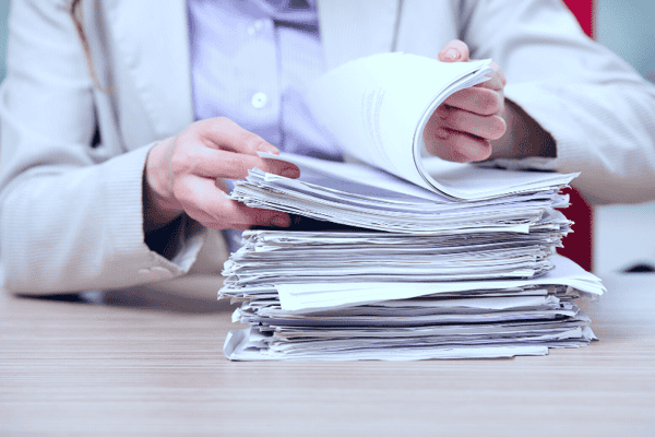 Businesswoman working with stack of papers