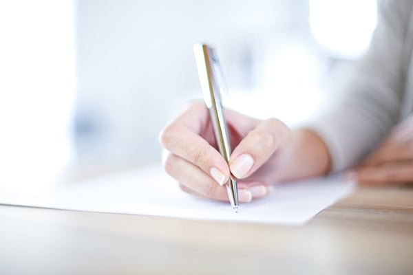 Closeup of womans hand writing on paper ULP filter