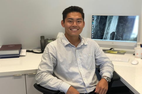 Man smiling in chair next to computer