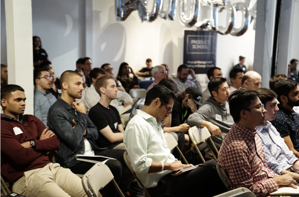 People-sitting-in-an-audience-listening-to-a-presentation-at-a-conference-1024x674-1