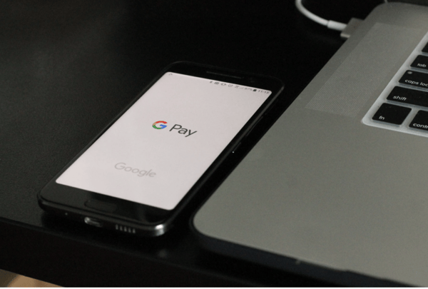 black Android smartphone with google pay near laptop computer