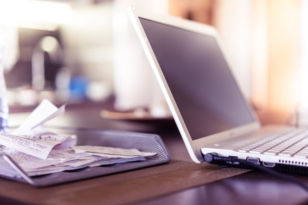 grey laptop next to receipts