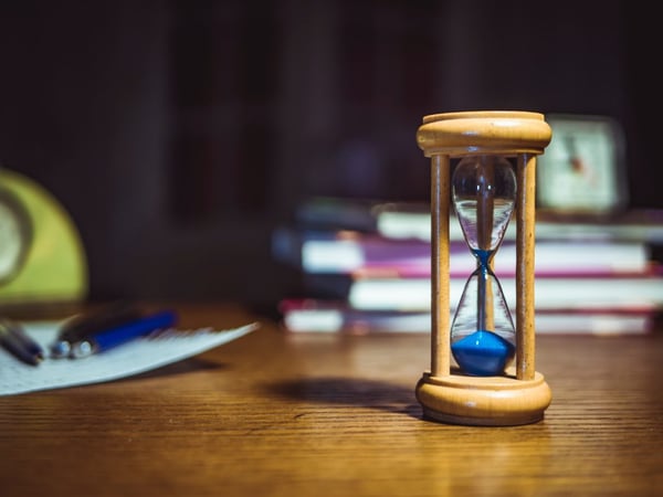 hourglass on table next to books