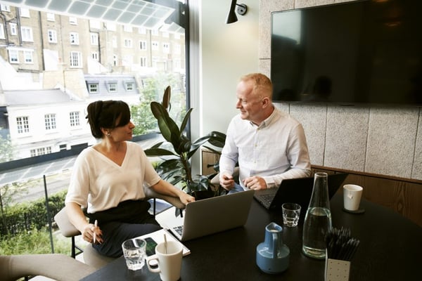 man and woman discussing and sharing ideas next to a table