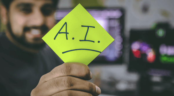 man holding sticky note that says artificial intelligence