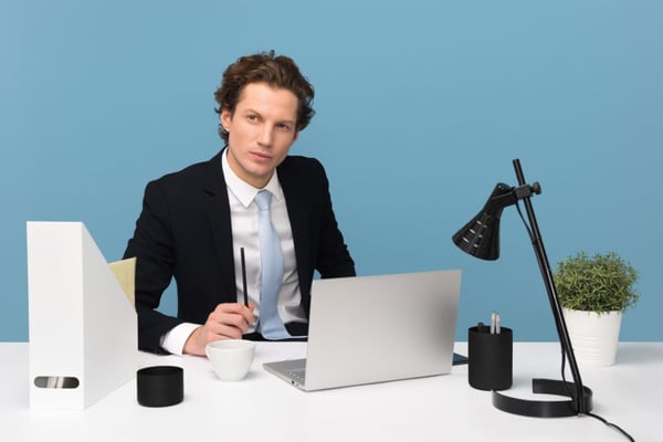 man sitting with laptop and computer
