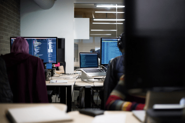 people on computer looking at code screens