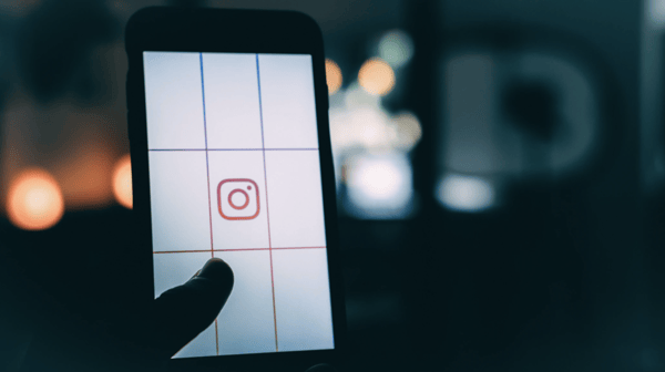 person using smartphone with Instagram logo screen grab bokeh photography