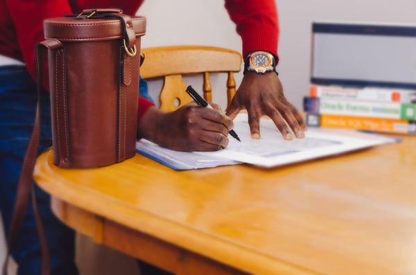 person writing on paper legal documents