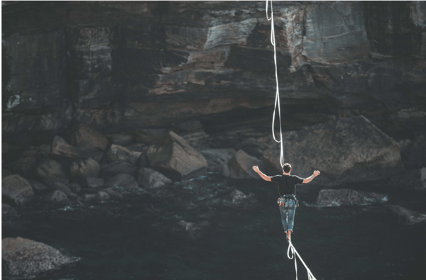 risk person walking on string
