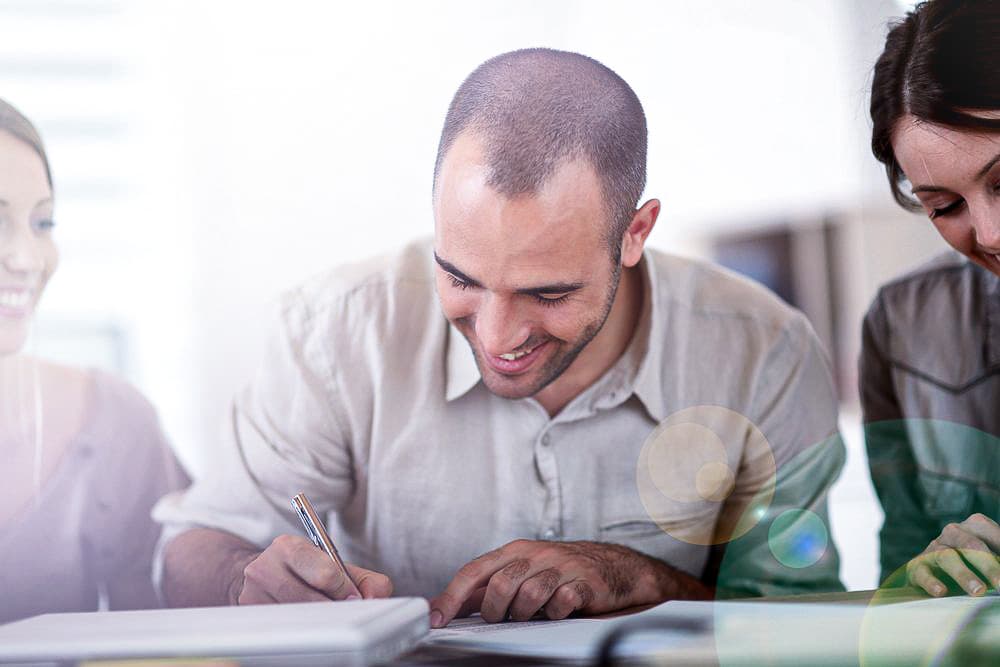 Portrait of young man filling in application form