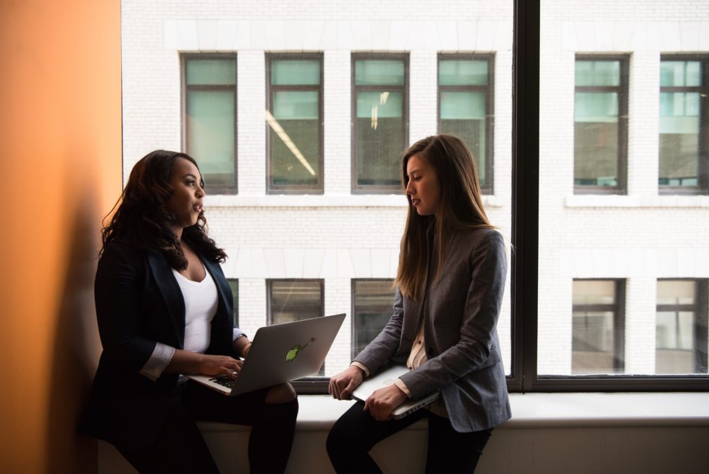 two women speaking to each other with laptop